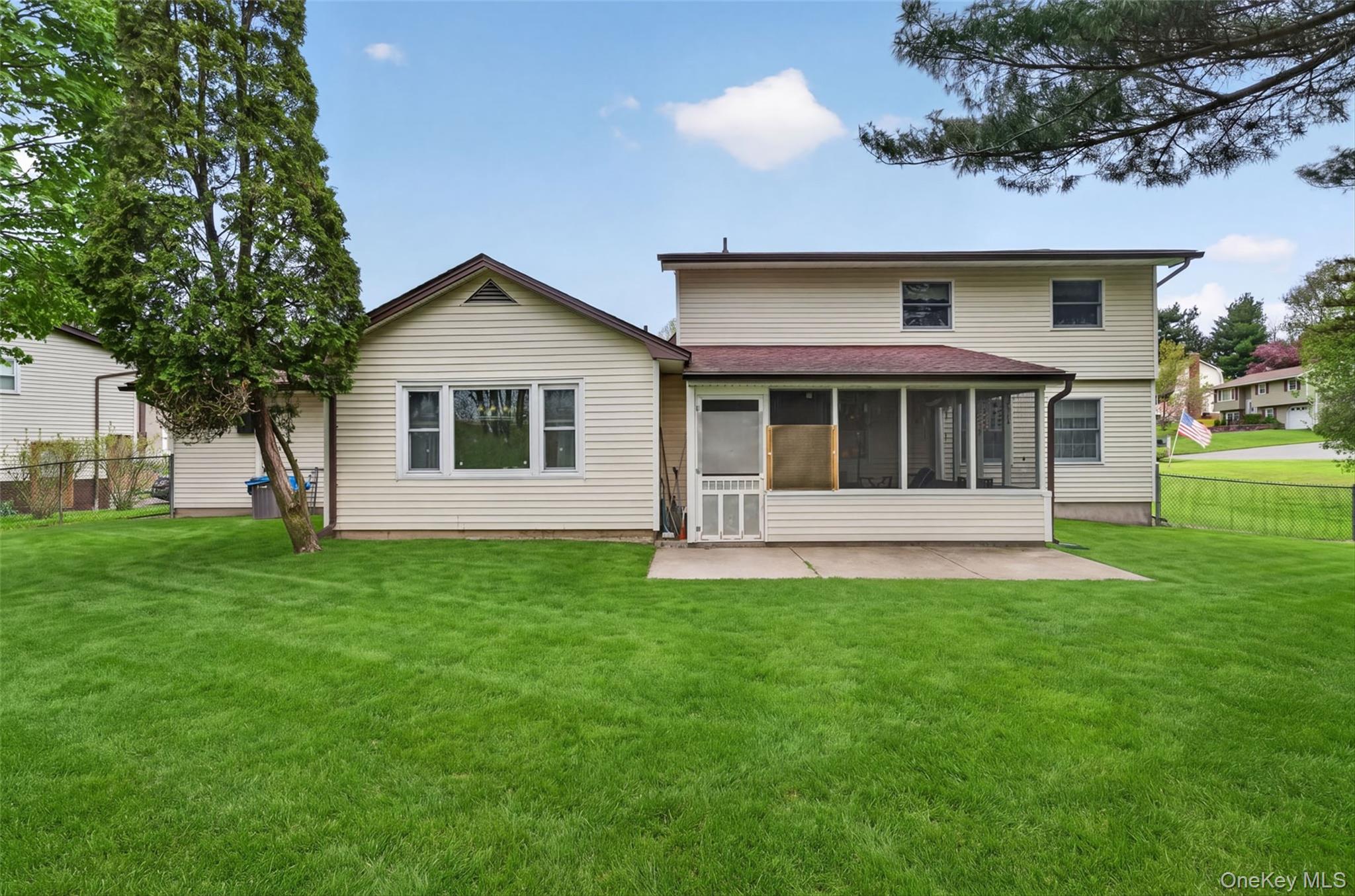 20 Oneil Circle Monroe, NY 10950 - Photo 42 of 45 Expansive rear yard featuring a screened-in porch, concrete patio, and a two-story exterior with siding