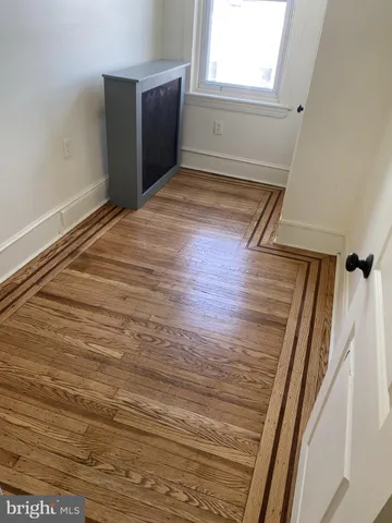 a view of a room with wooden floor and window