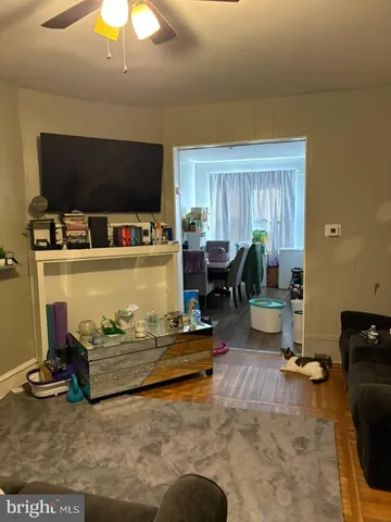 a living room with kitchen view and a flat screen tv
