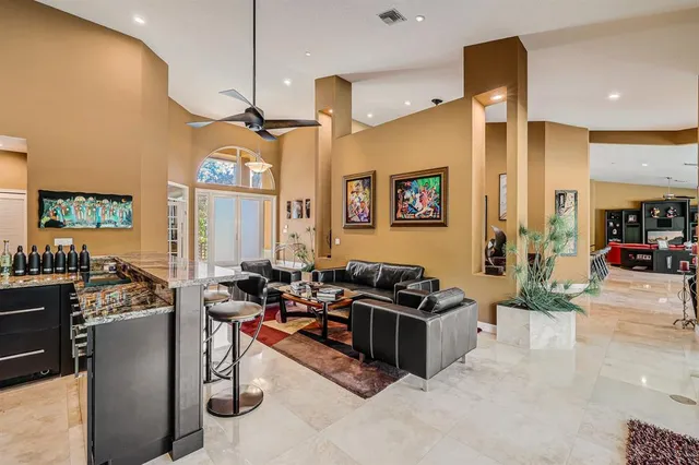 a living room with furniture a floor to ceiling window and a flat screen tv