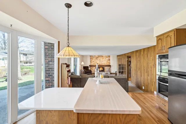 a living room with furniture a large window and kitchen view