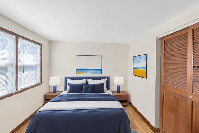 a bedroom with a bed and painting on the wall