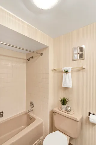a white toilet sitting next to a bath tub