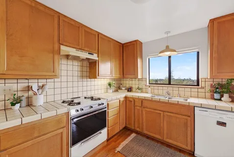 a kitchen with a sink stove and cabinets