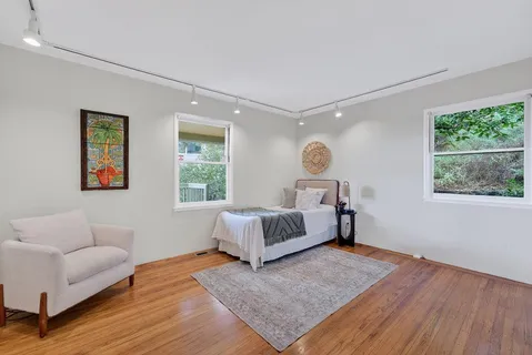 a spacious bedroom with a bed couch and window