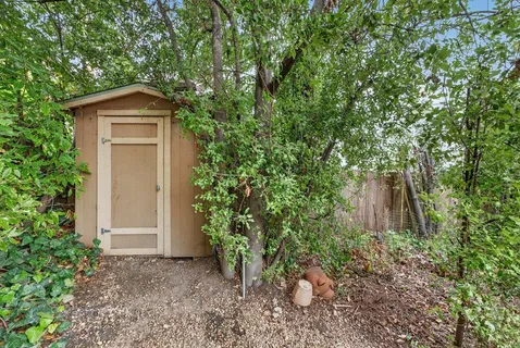 a view of a house with a yard and large trees