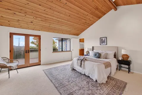 a spacious bedroom with a bed a table and painting on the wall