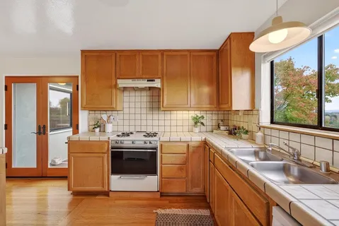 a kitchen with stainless steel appliances a sink stove and cabinets