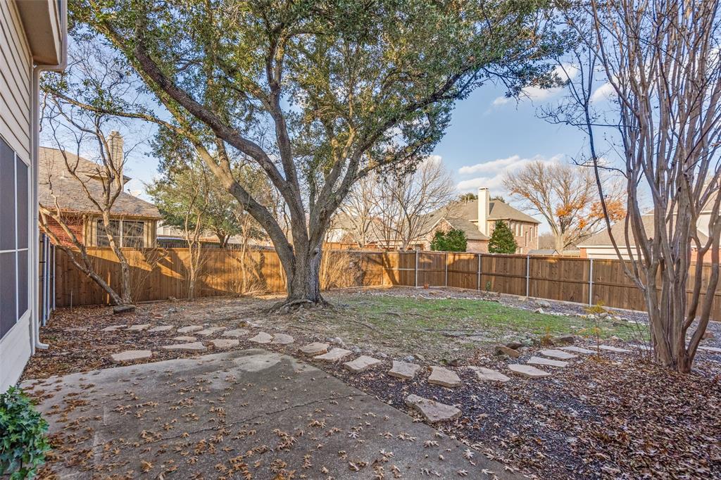 2248 Amy Lane Plano, TX 75074 - Photo 24 of 26 back patio with wooden fence and mature trees