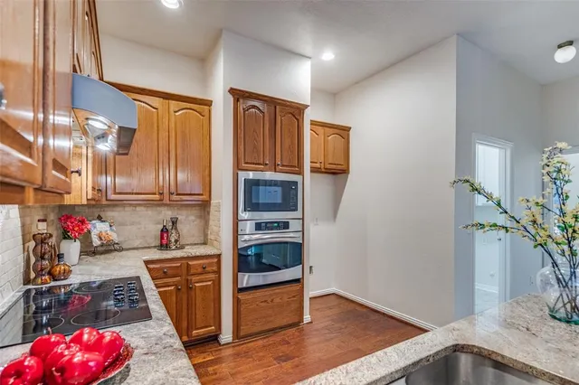 an empty room with wooden floor fireplace and windows