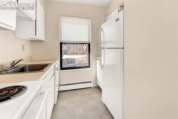 a view of a kitchen with a sink and wooden floor