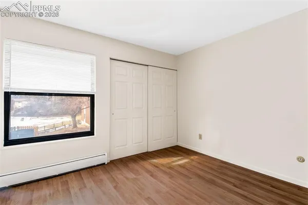 a view of an empty room with wooden floor