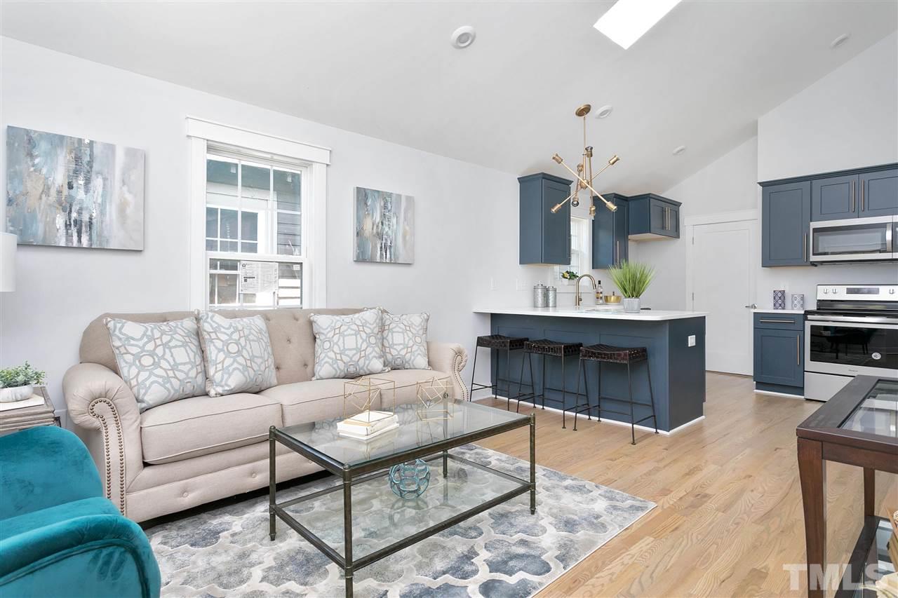 111 Bart Street Raleigh, NC 27610 - Photo 4 of 22 a living room with furniture a fireplace and a kitchen view