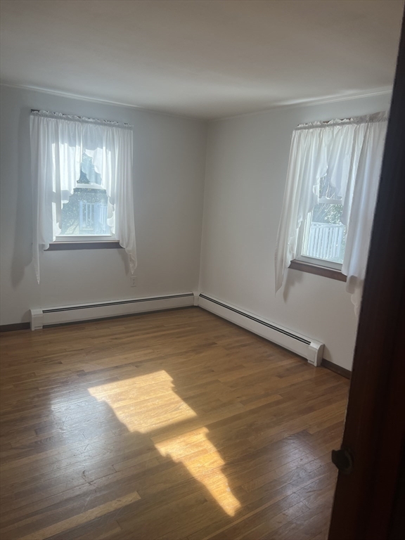 6 A Maple Avenue, Unit 6A Scituate, MA 02066 - Photo 13 of 21 a view of an empty room with wooden floor and a window