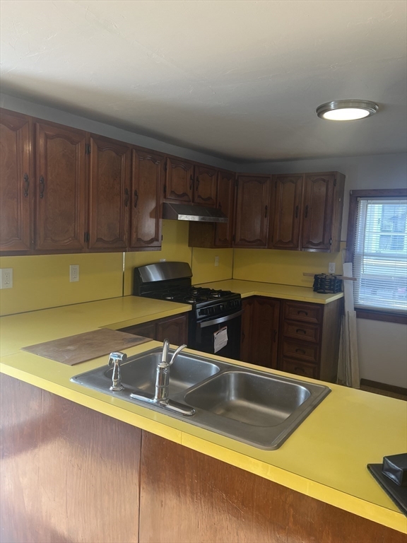 6 A Maple Avenue, Unit 6A Scituate, MA 02066 - Photo 7 of 21 a kitchen with a sink and wooden cabinets