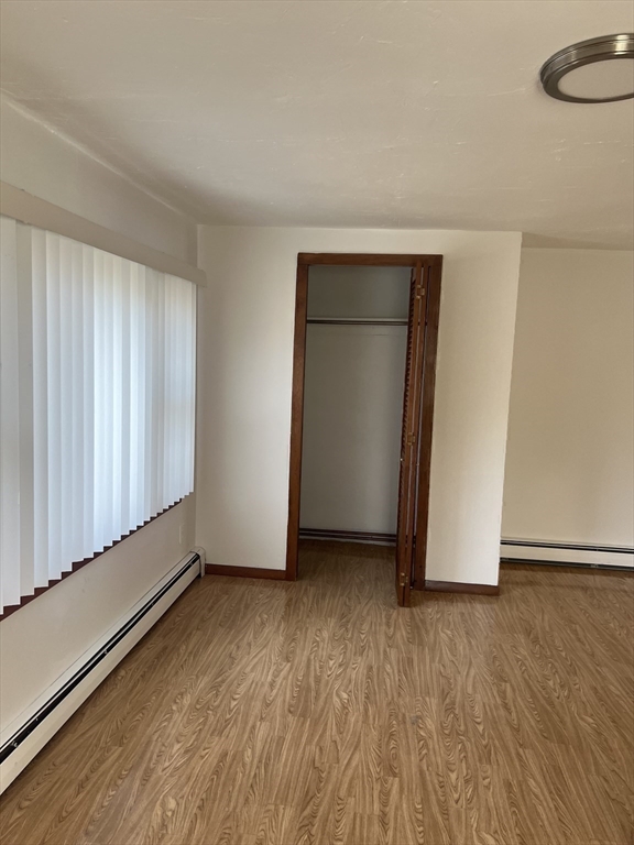 6 A Maple Avenue, Unit 6A Scituate, MA 02066 - Photo 9 of 21 an empty room with wooden floor and windows