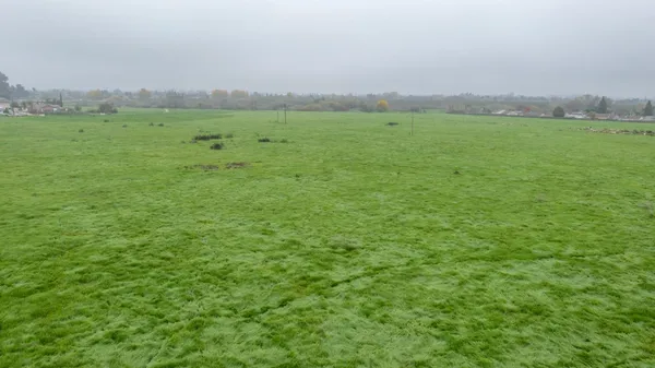 a view of a green field with an outdoor space