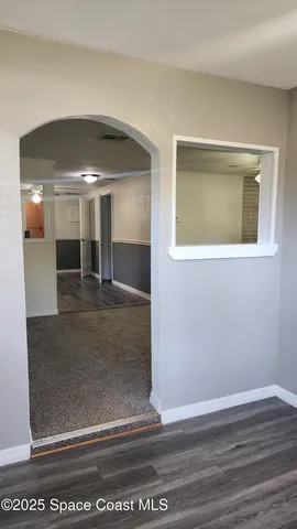 a view of a hallway with wooden floor