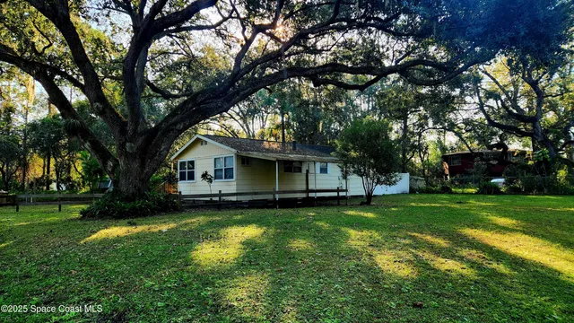 a house with a big yard and large trees
