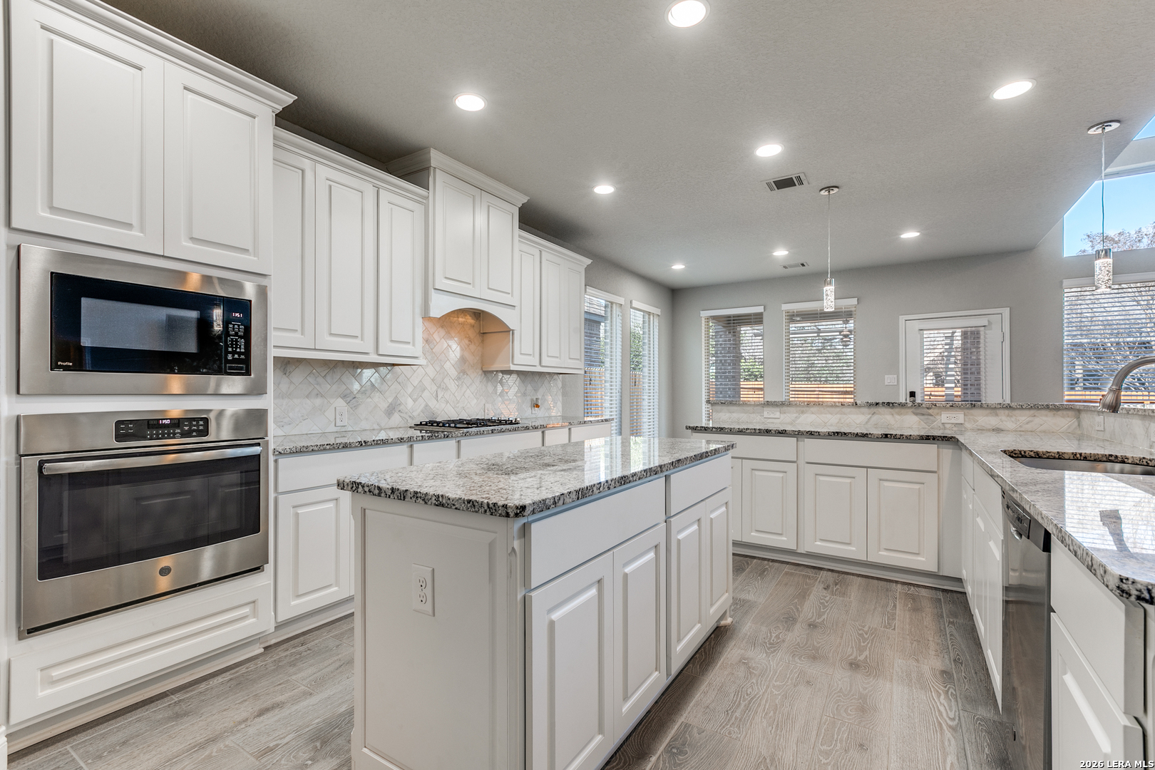 331 Ricadonna San Antonio, TX 78253 - Photo 12 of 28 a kitchen with kitchen island granite countertop white cabinets stainless steel appliances and a sink