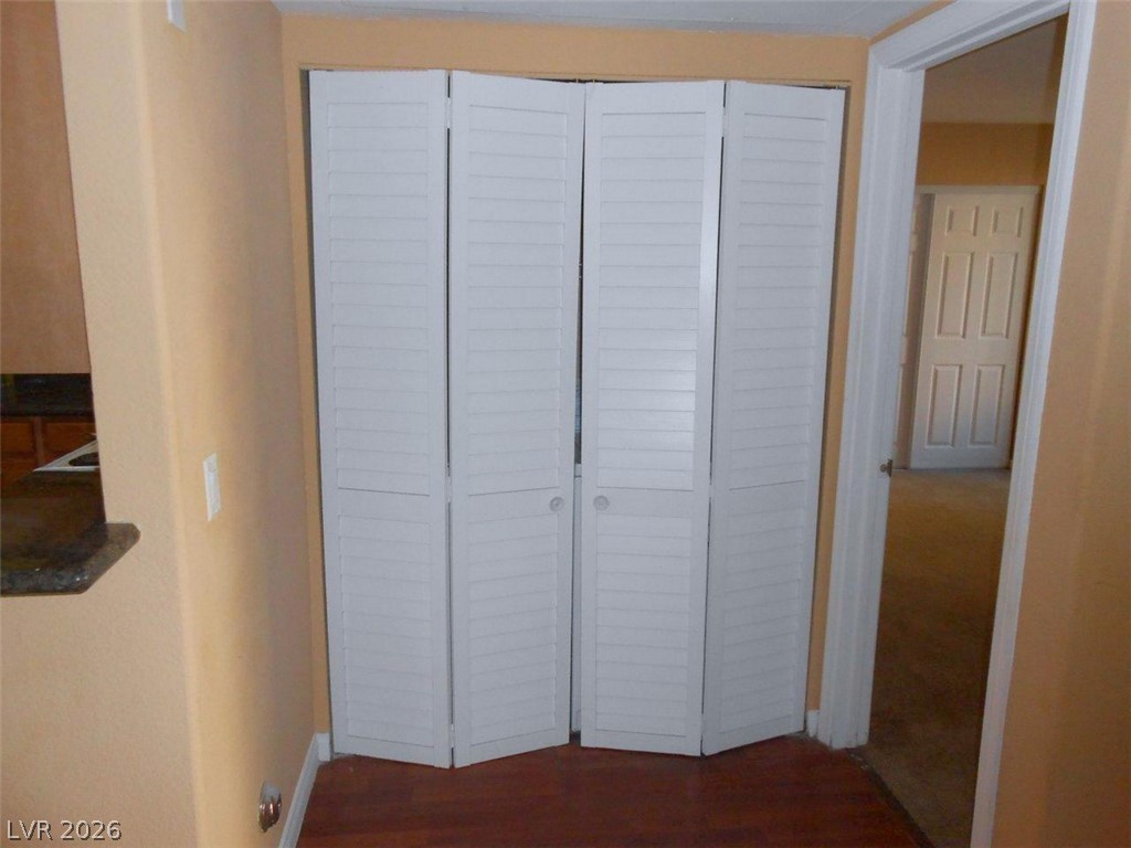 9325 West Desert Inn Road, Unit 132 Las Vegas, NV 89117 - Photo 6 of 36 Louvered bi-fold doors conceal a practical storage space, complementing the rich wood flooring.