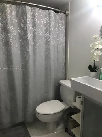 a bathroom with a shower curtain and a toilet