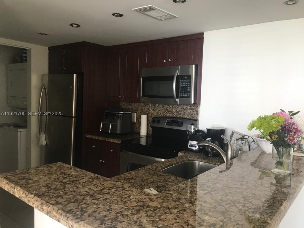 770 Claughton Island Drive, Unit 1404 Miami, FL 33131 - Photo 6 of 23 a kitchen with a refrigerator and a sink