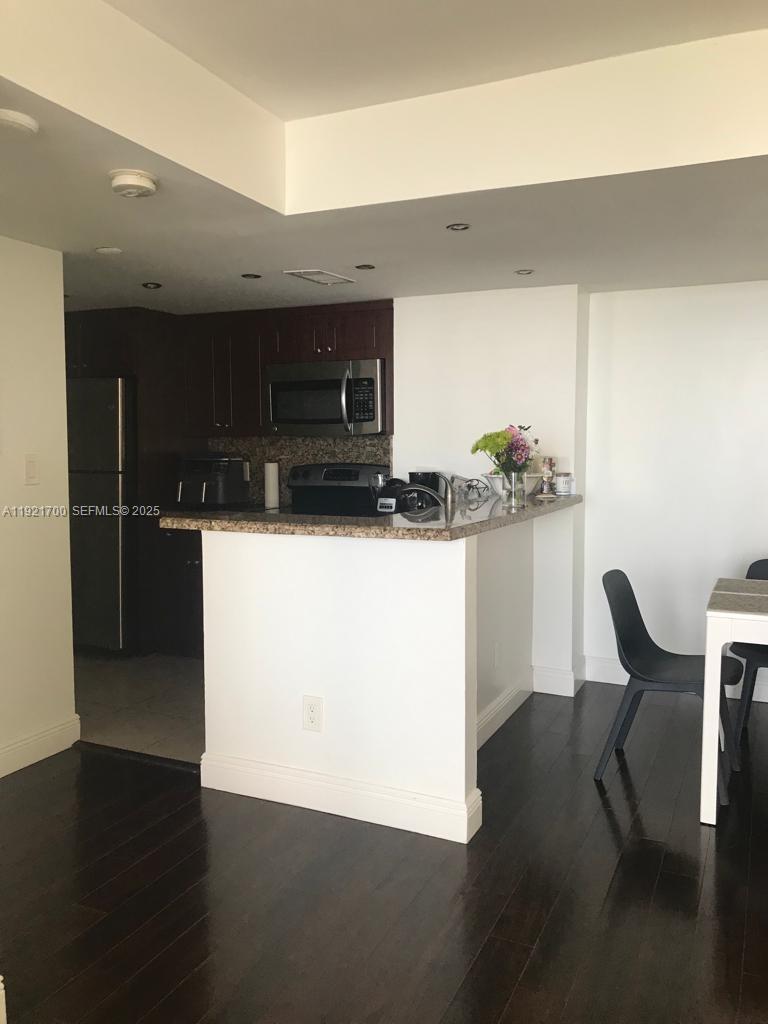 770 Claughton Island Drive, Unit 1404 Miami, FL 33131 - Photo 7 of 23 a kitchen with a sink a refrigerator and chairs
