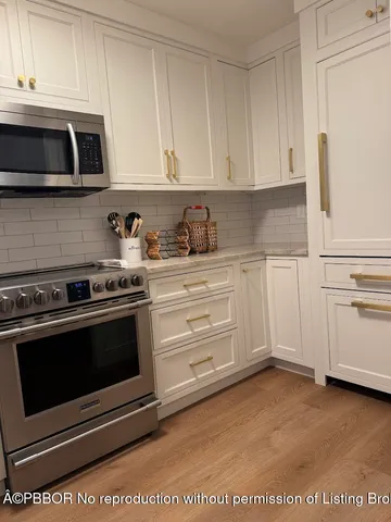 a kitchen with granite countertop white cabinets and stainless steel appliances