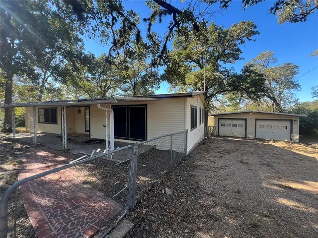 a view of a house with a yard and large tree