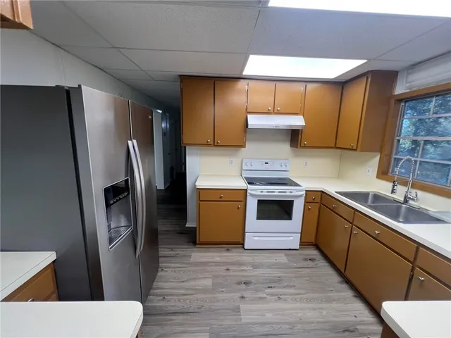 a kitchen with stainless steel appliances a stove a refrigerator and a sink