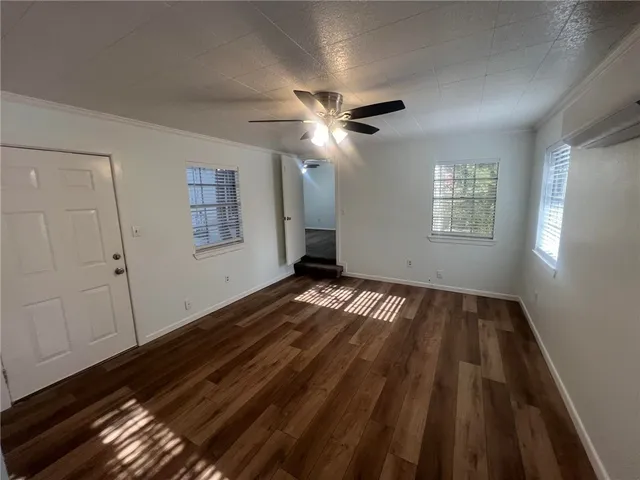 a view of empty room with wooden floor