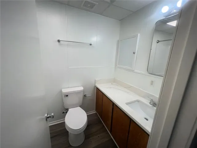 a bathroom with a granite countertop toilet and a sink
