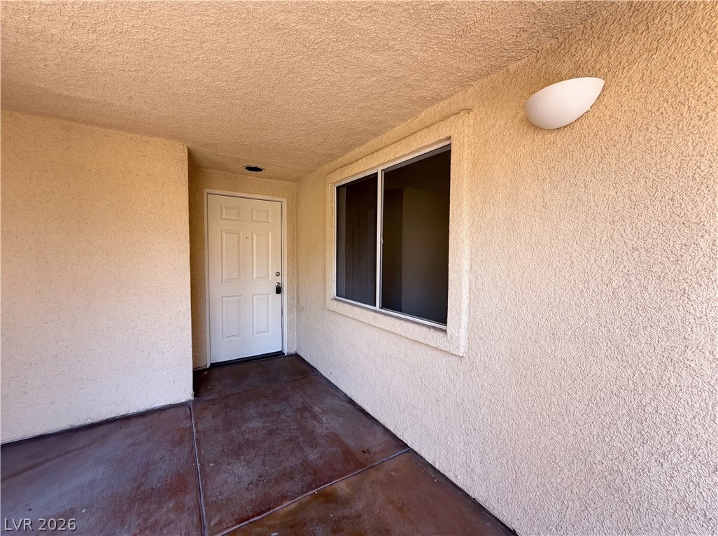 230 East Flamingo Road, Unit 320 Las Vegas, NV 89169 - Photo 2 of 19 A welcoming entry offers a secure white paneled door and large window, illuminated by a modern sconce.