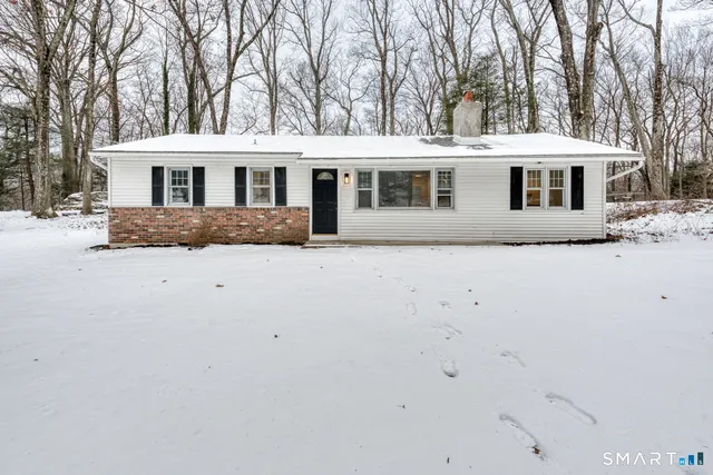 a front view of house with a yard covered in snow