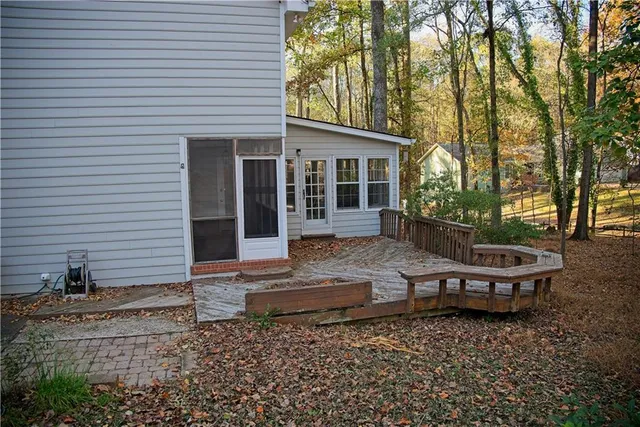 a backyard of a house with wooden floor and outdoor seating