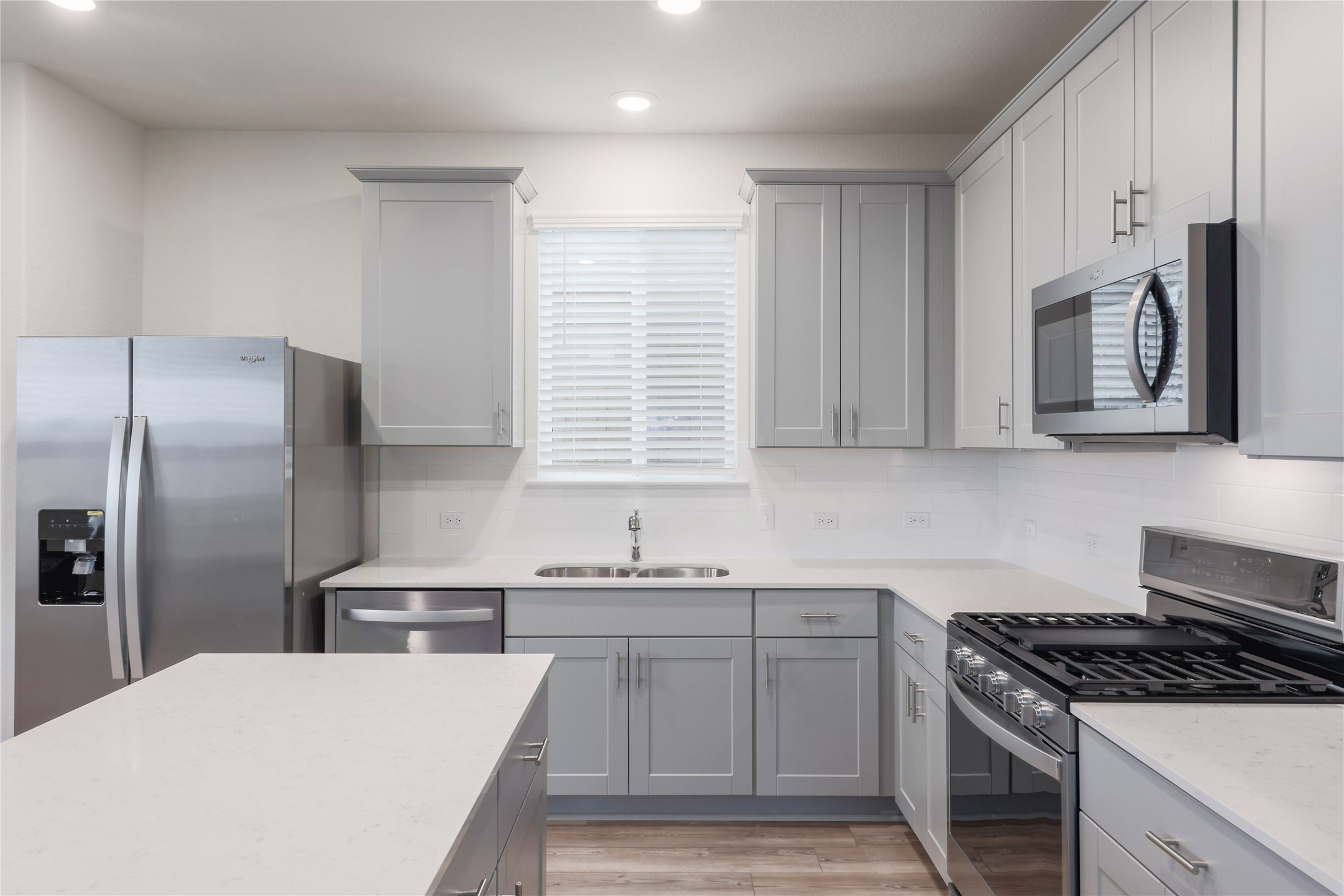 212 Sugar Cane Road Buda, TX 78610 - Photo 11 of 40 Beautiful kitchen featuring quartz counters and painted shaker cabinetry.