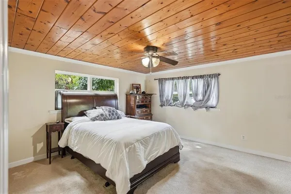 a bedroom with a bed and a chandelier fan