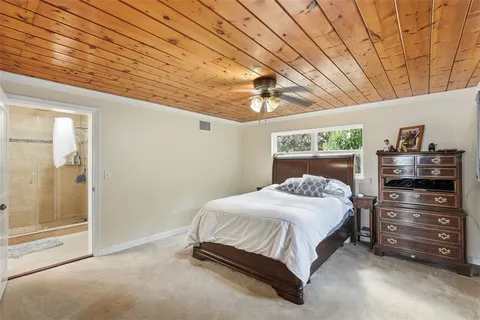 a bedroom with a bed and a chandelier fan