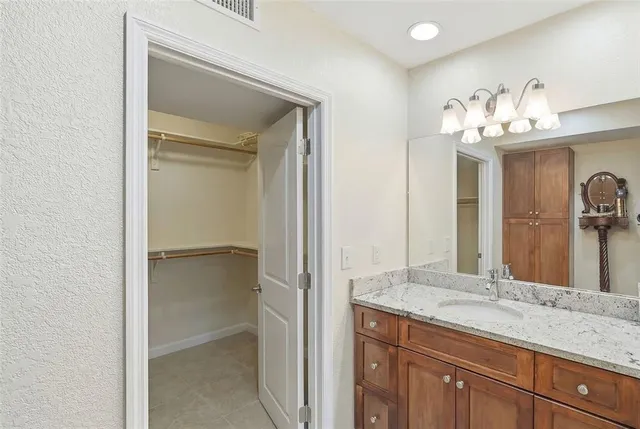 a bathroom with a granite countertop sink a mirror and a bathtub