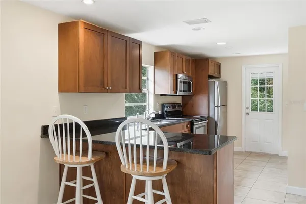 a view of a house with backyard and trees