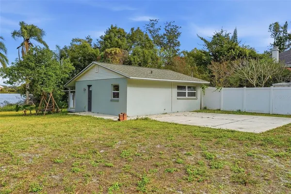 a view of a house with backyard and a tree