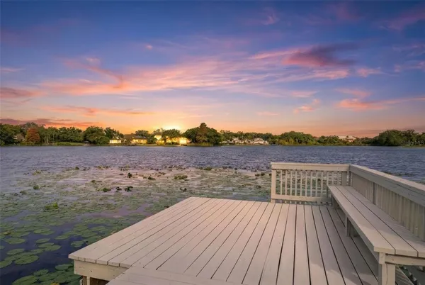 an aerial view of a houses with a yard and lake view