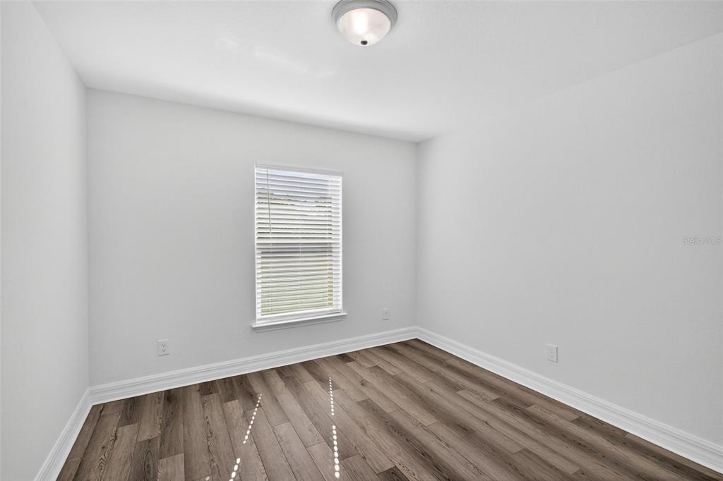 11145 2nd Avenue Punta Gorda, FL 33955 - Photo 7 of 9 a view of an empty room with wooden floor and a window