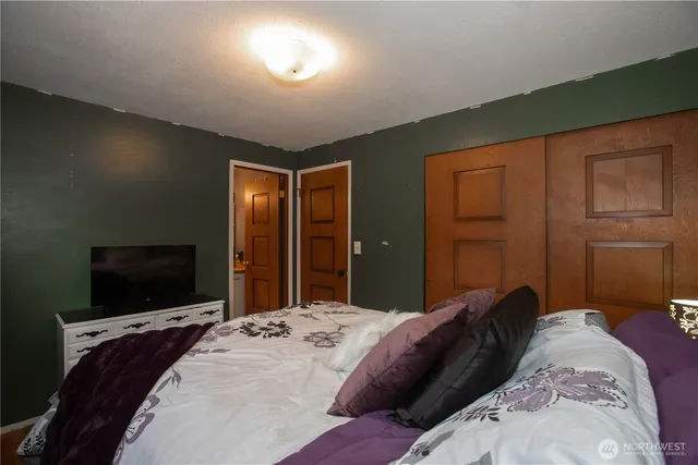 a bedroom with a bed and a flat screen tv