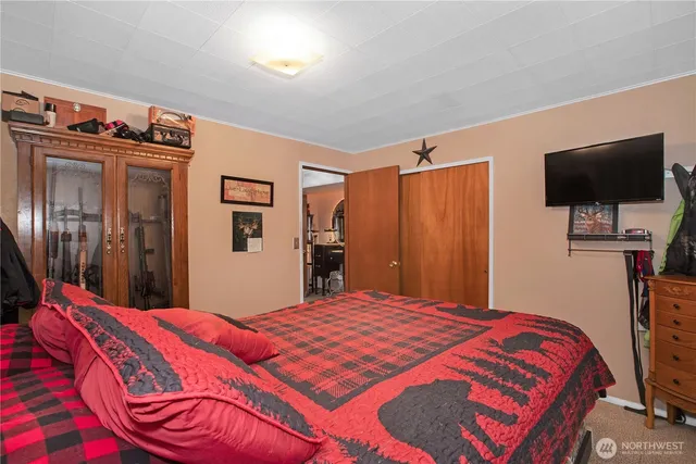 a bedroom with a bed and a flat screen tv