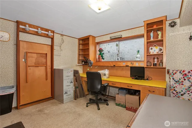 a view of a workspace with furniture and a window