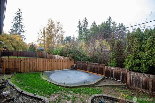 a view of a backyard with wooden fence