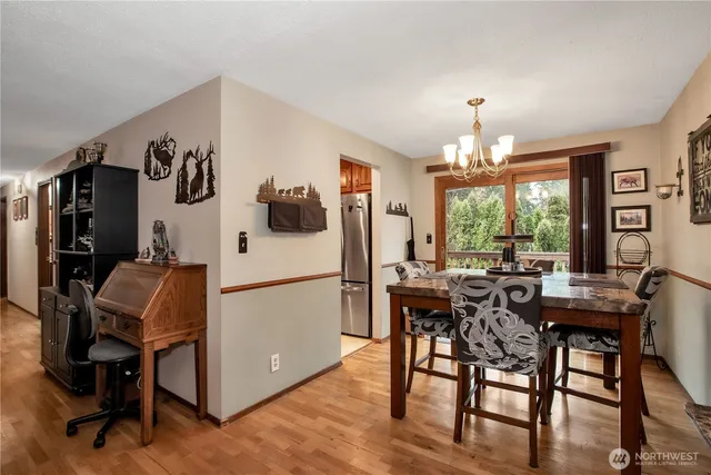 a white kitchen with a table chairs and refrigerator
