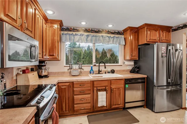 a kitchen with stainless steel appliances a sink stove and refrigerator